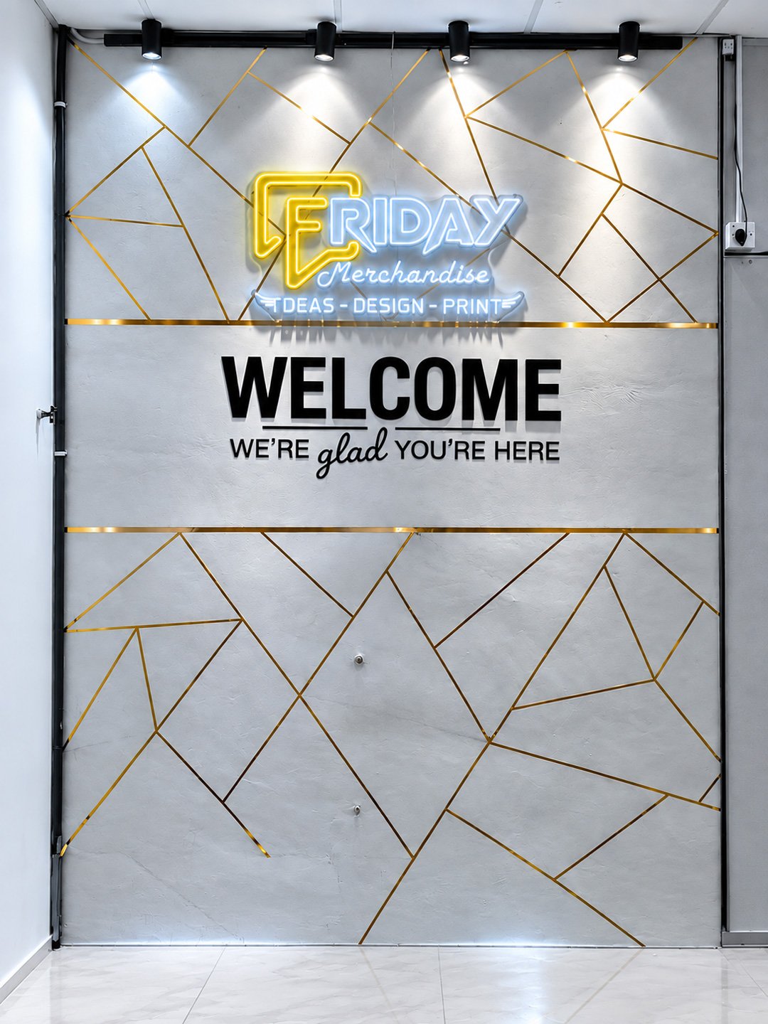 Friday Merchandise reception wall with neon logo and gold geometric accents, welcoming visitors to the ideas, design, and print studio.